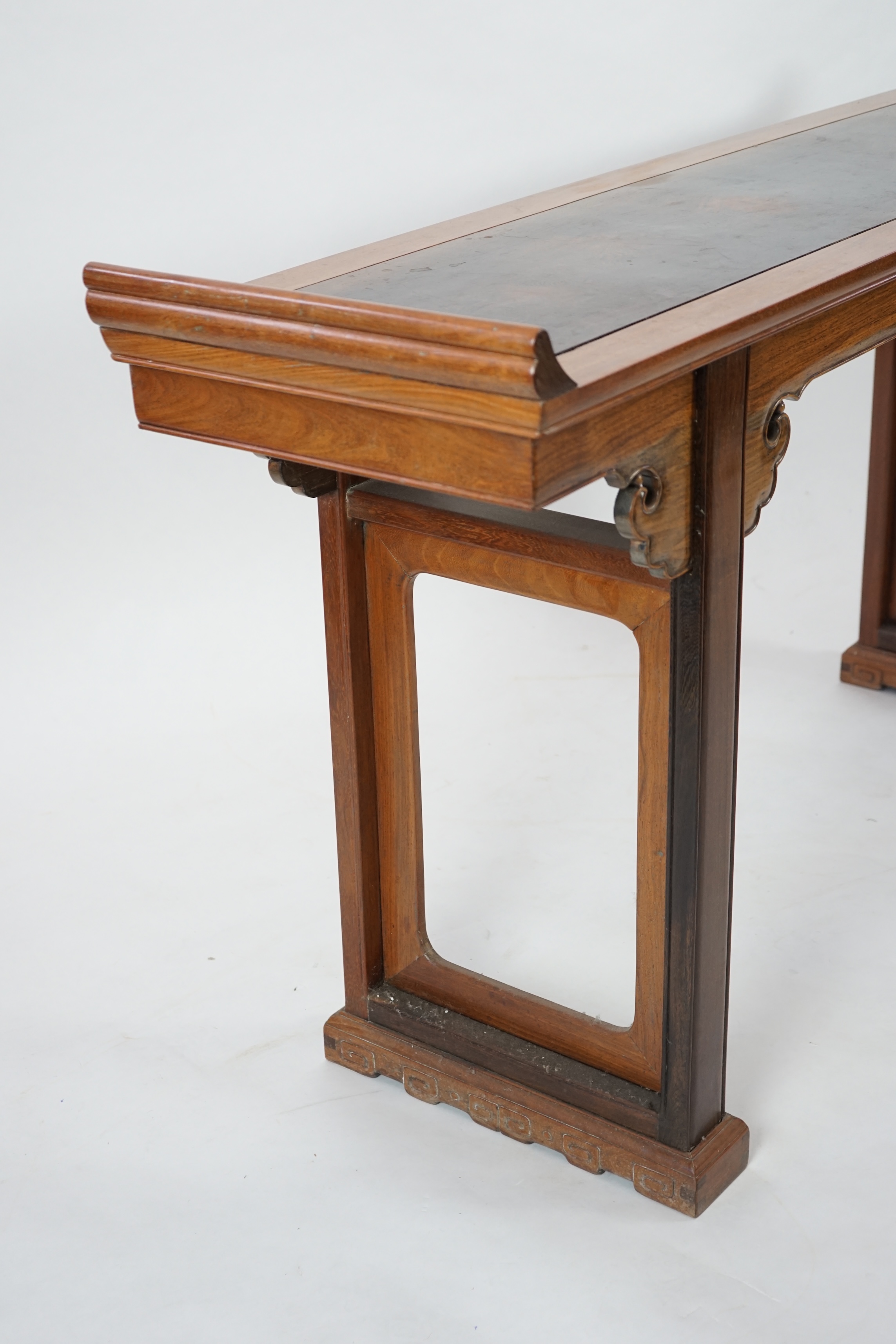 A Chinese padouk wood and jichimu altar table, the panelled rectangular top with scroll ends, on plain uprights headed by ruyi, 185cm wide, 94cm high. Condition - fair to good